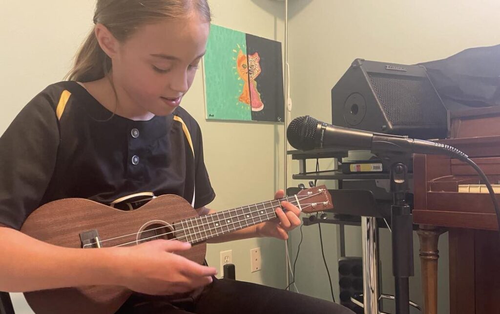 a child learning how to play ukulele musical instrument in Harana Music Academy